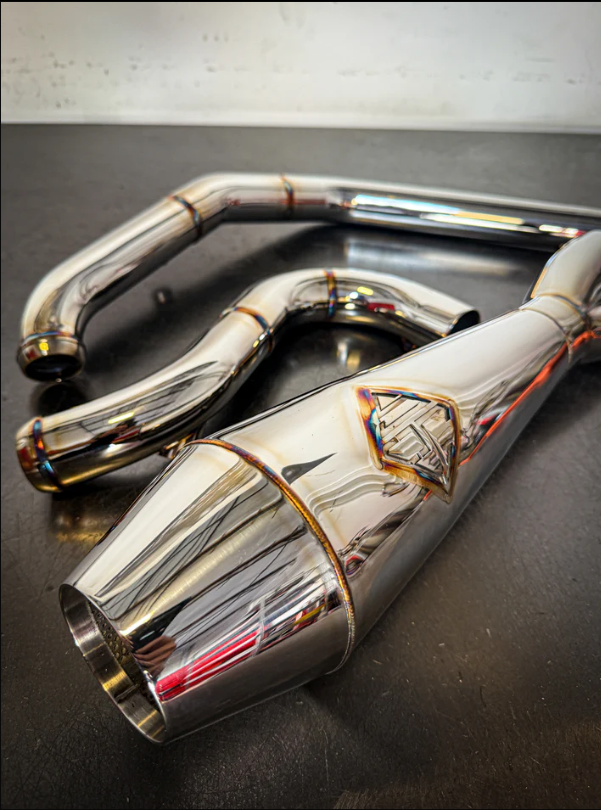 Chrome exhaust pipes on a dark surface